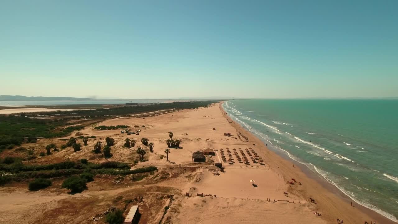 游客在海滩上度假时探索大海的航拍，无人机向前飞向在景观上布置的阴影-杰尔巴，突尼斯视频素材