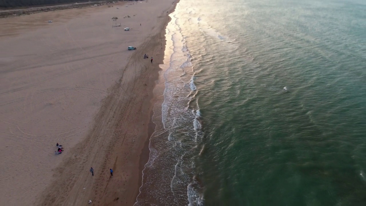 空中向后拍摄的游客在海滩海岸线在日落期间度假-杰尔巴，突尼斯视频素材