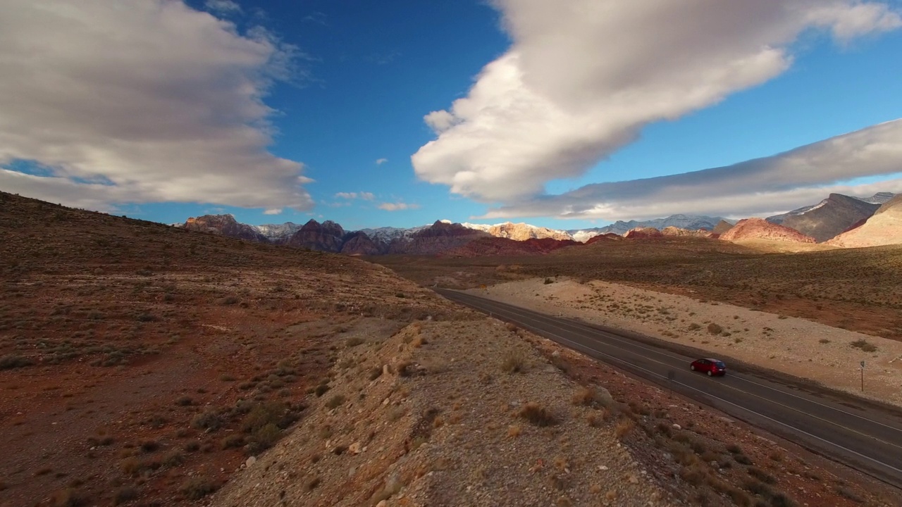 空中前进风景拍摄的汽车在沙漠道路上移动，对抗多云的天空-拉斯维加斯，内华达州视频素材