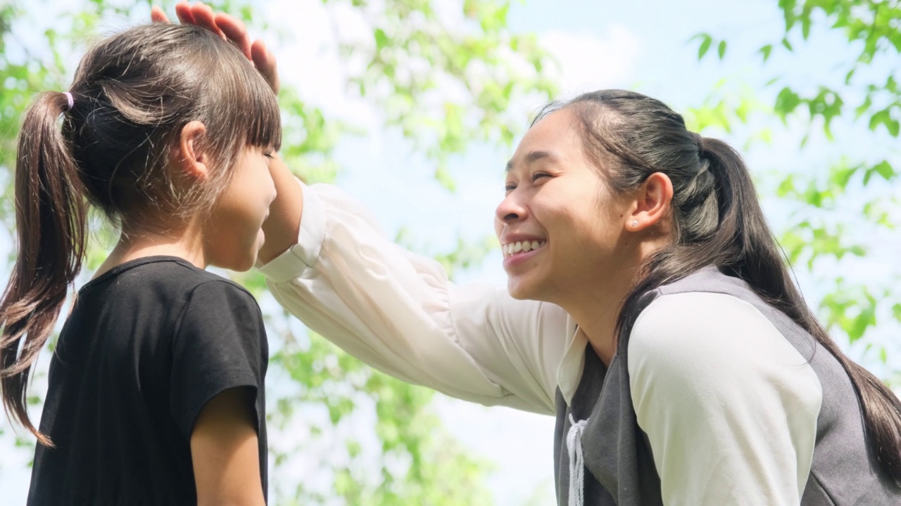 快乐的妈妈和她的女儿在公园里玩。一家人一起度假。视频素材