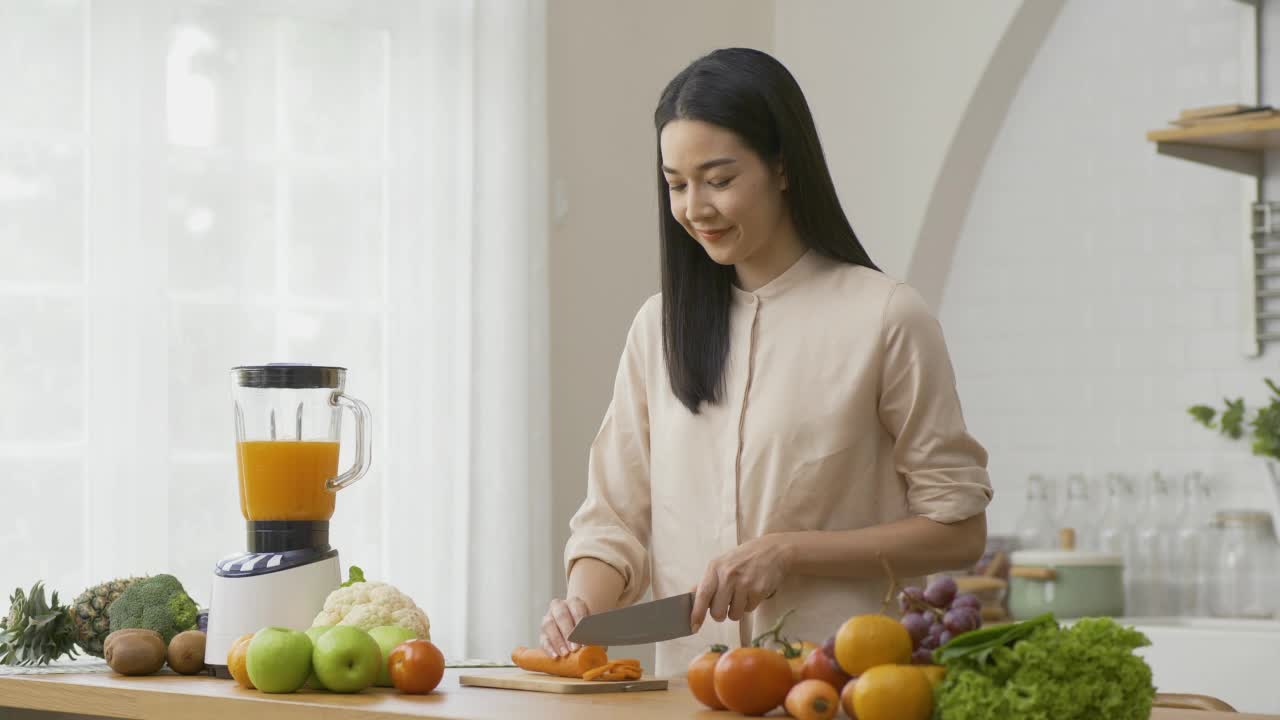 漂亮的亚洲女人在厨房做饭。保健和饮食的概念。视频素材