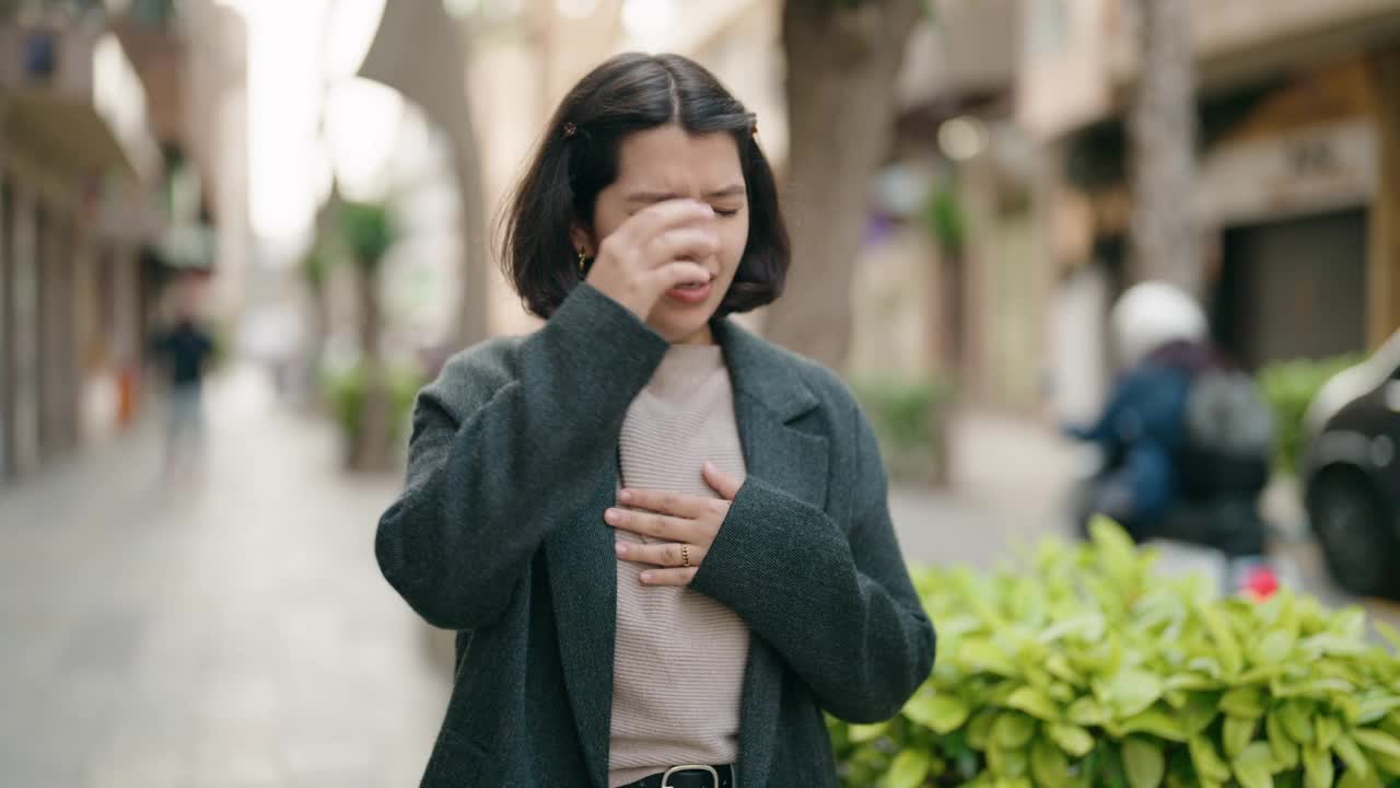 年轻的西班牙女孩在街上咳嗽视频素材