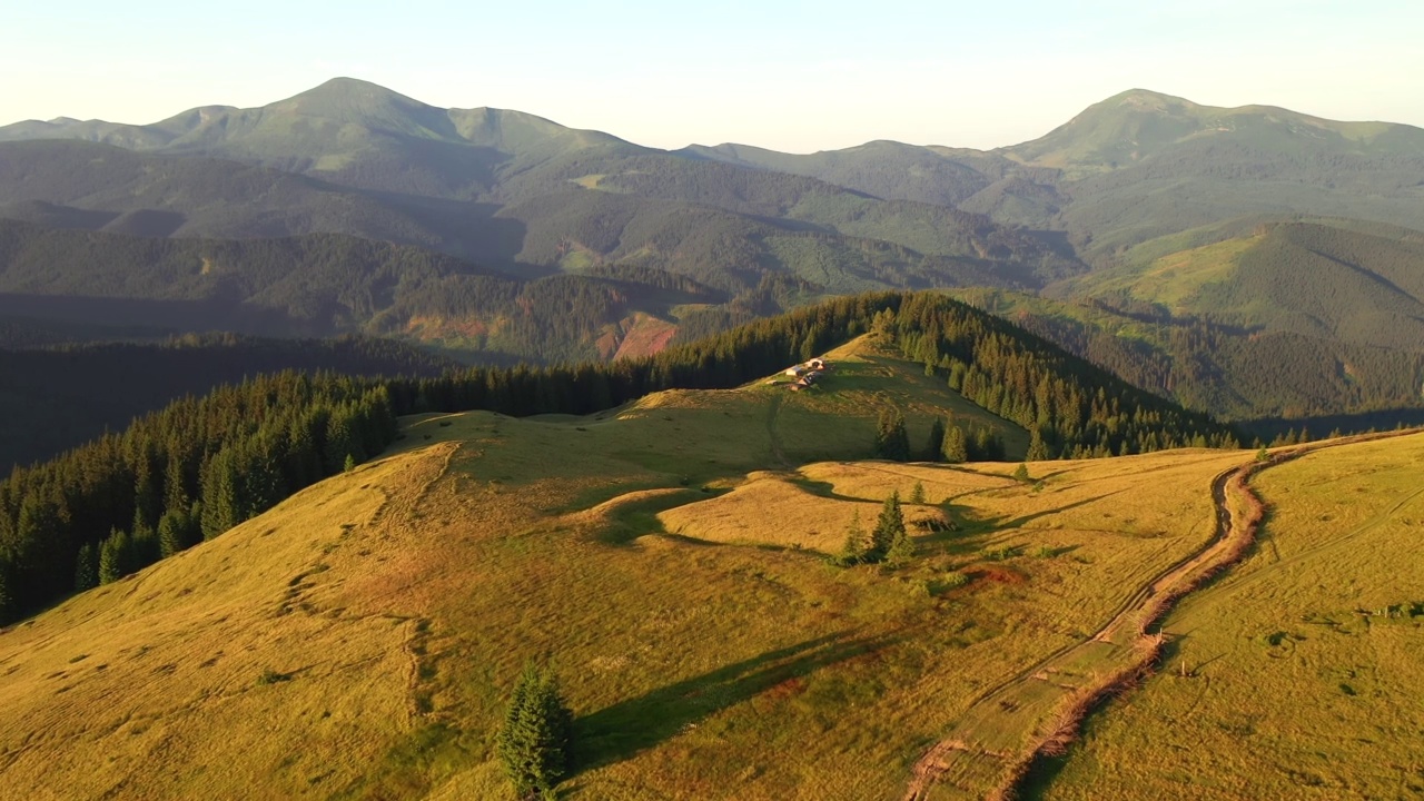 在阳光明媚的一天，航拍的绿色高山牧场。视频素材