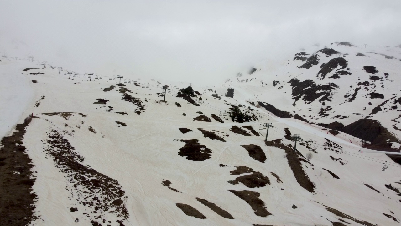 航拍的一个滑雪场没有人，山坡受雾霾影响，积雪呈棕色视频素材