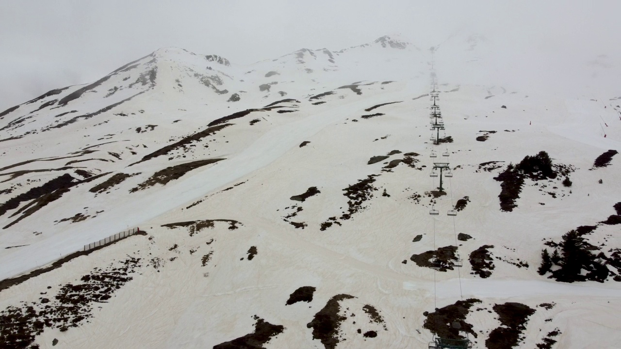 航拍的一个滑雪场没有人，山坡受雾霾影响，积雪呈棕色视频素材