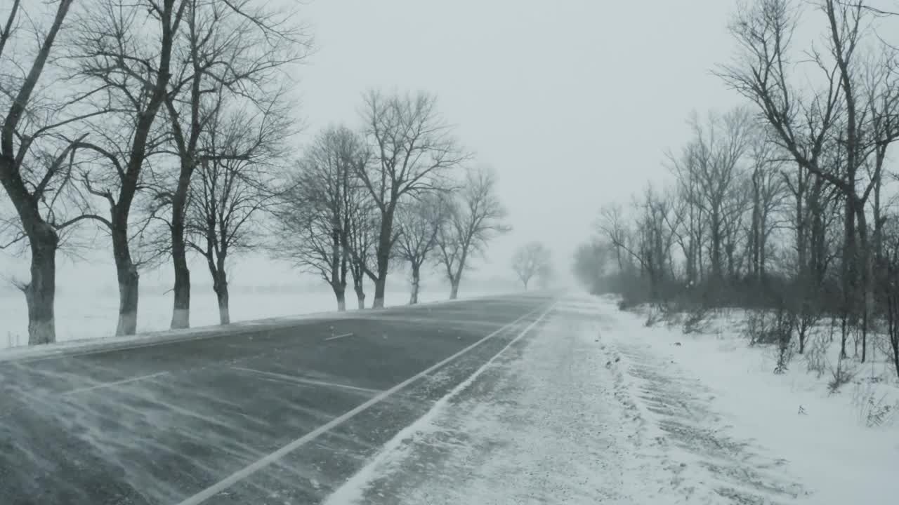 汽车在暴风雪的冬季道路上视频素材