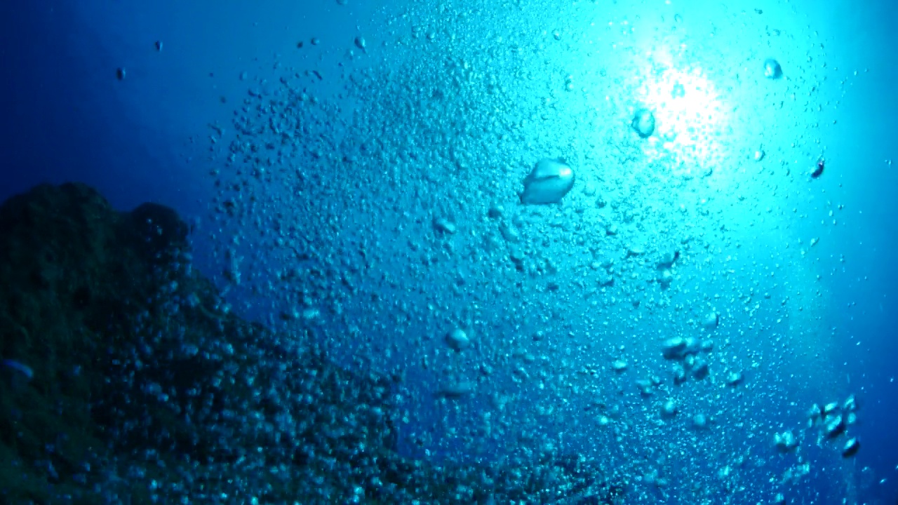 水下接近水面与天空的海洋风景，阳光光束，阳光射线和气泡缓慢放松的海洋背景视频素材