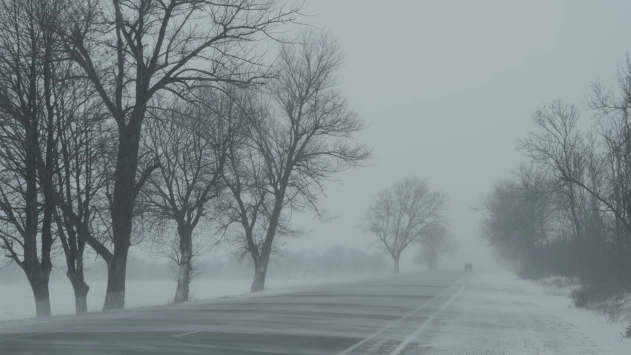 汽车在暴风雪的冬季道路上视频素材