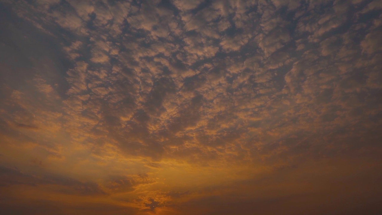 日落时天空中的云的全景式镜头。乌云在日落时形成背景。日落时云变成橘黄色。视频素材