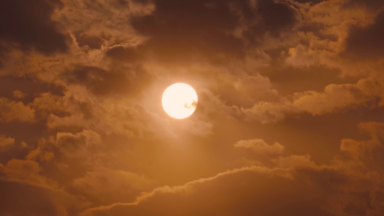 日落时太阳在云层后面的特写镜头。夕阳下的太阳。日落的自然背景视频素材