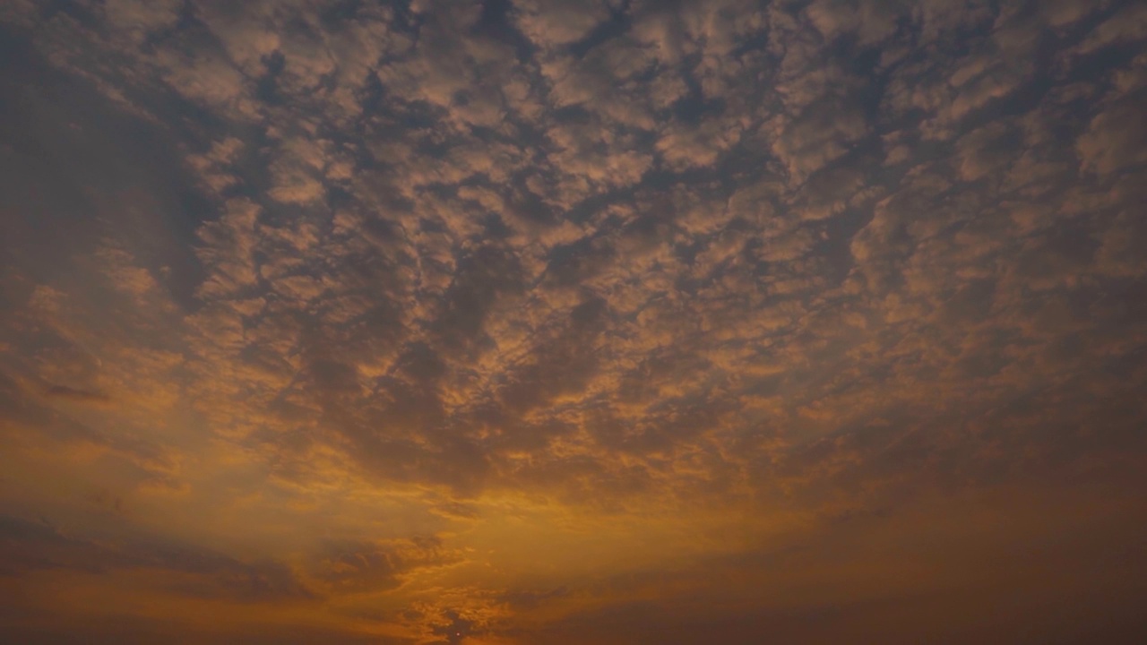 日落时天空中的云的全景式镜头。乌云在日落时形成背景。日落时云变成橘黄色。视频素材