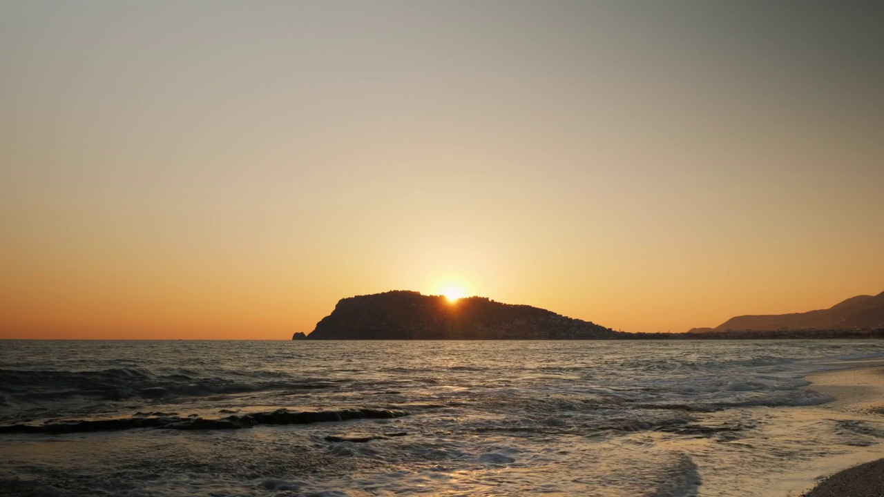 热带夏季日落。橙色的太阳落在海面上。日出橘黄色云景和岩石海岸。令人惊叹的日落在平静的海上视频素材