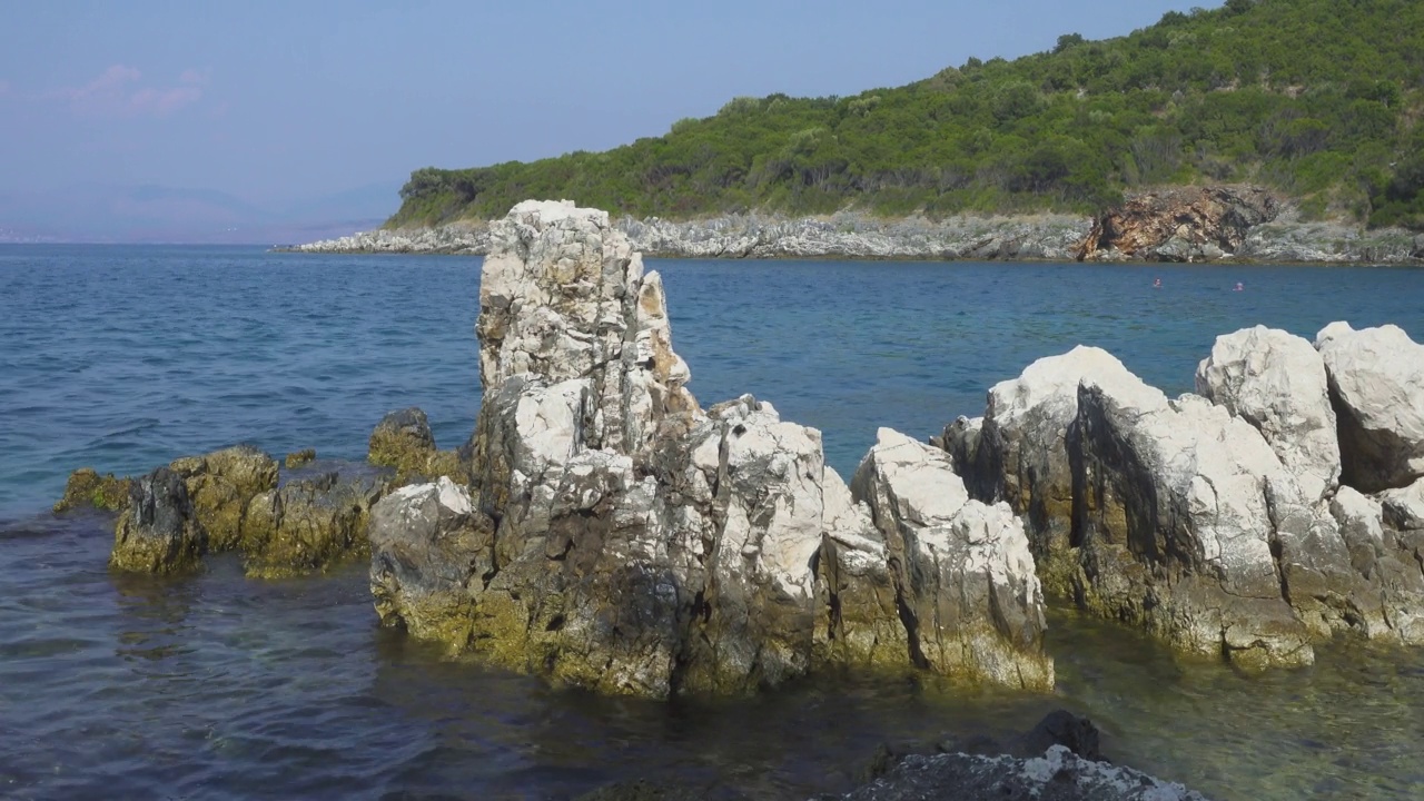 希腊岛屿的岩石海岸和平静的蓝色海面上的海浪视频素材