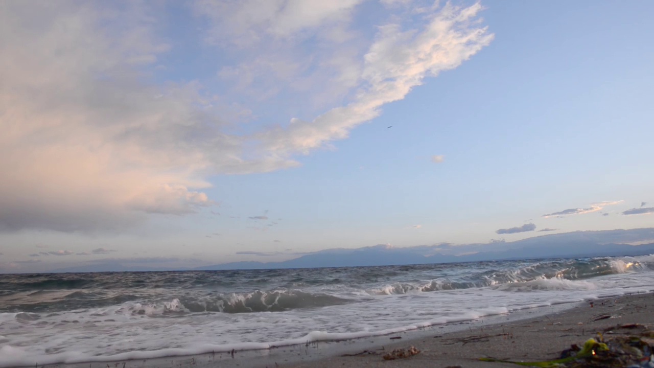 在希腊的日落时分，海浪拍打着海滩视频素材