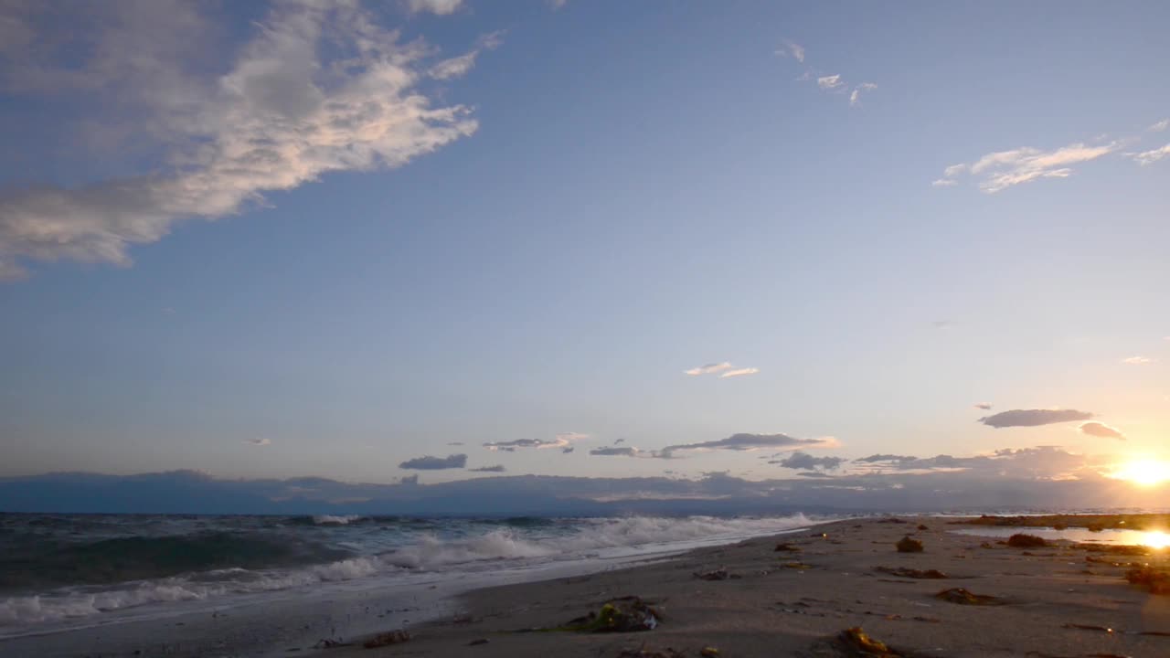 在希腊的日落时分，海浪拍打着海滩视频素材