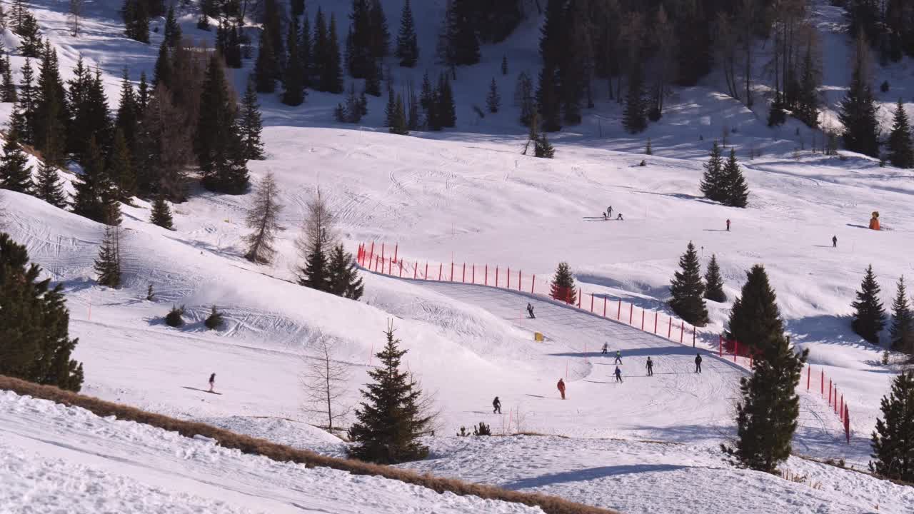 一群高山滑雪者从美丽的雪坡上滑下来，雪坡并不太陡视频素材