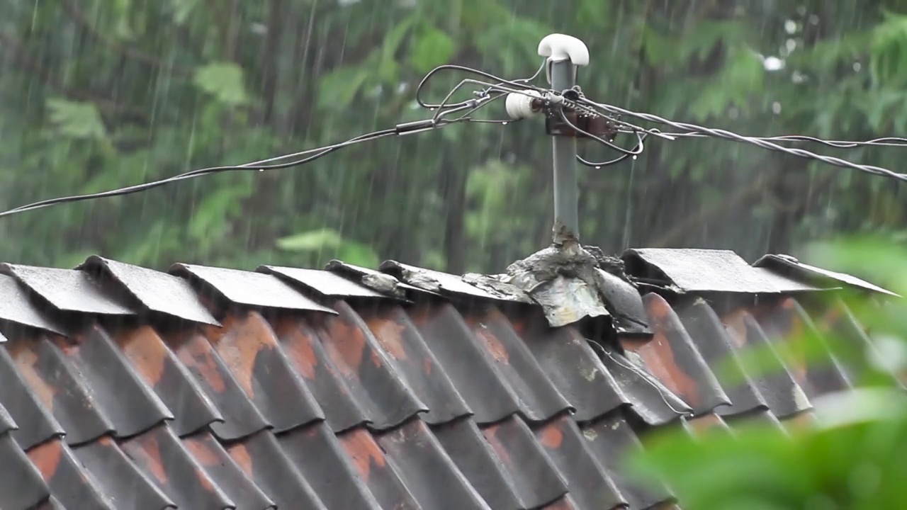 大量的雨水落在由粘土制成的棕色瓦片上，这是印尼爪哇省农村地区屋顶的特点视频素材