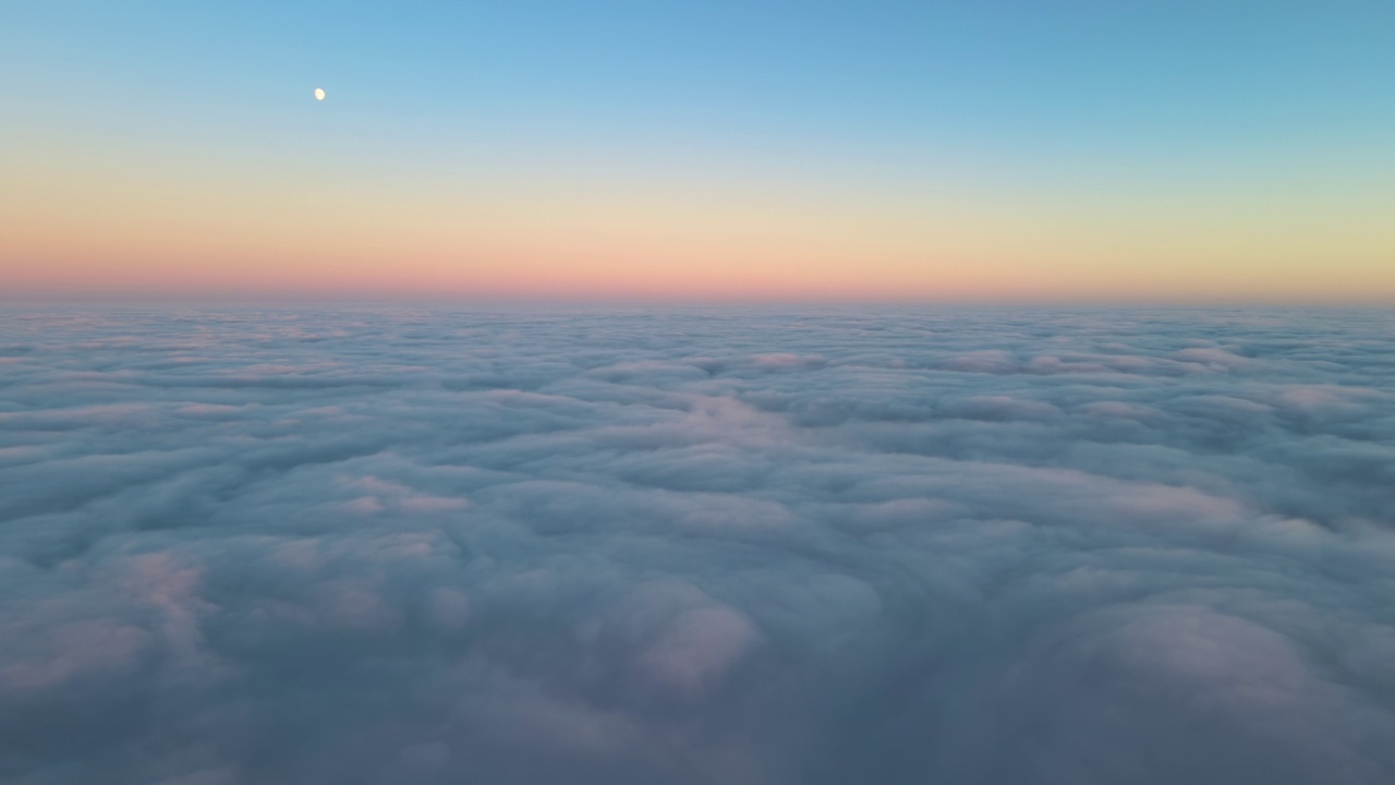 从高空俯瞰，浓密蓬松的积云在傍晚飞舞。从飞机窗口看到的令人惊叹的日落视频素材