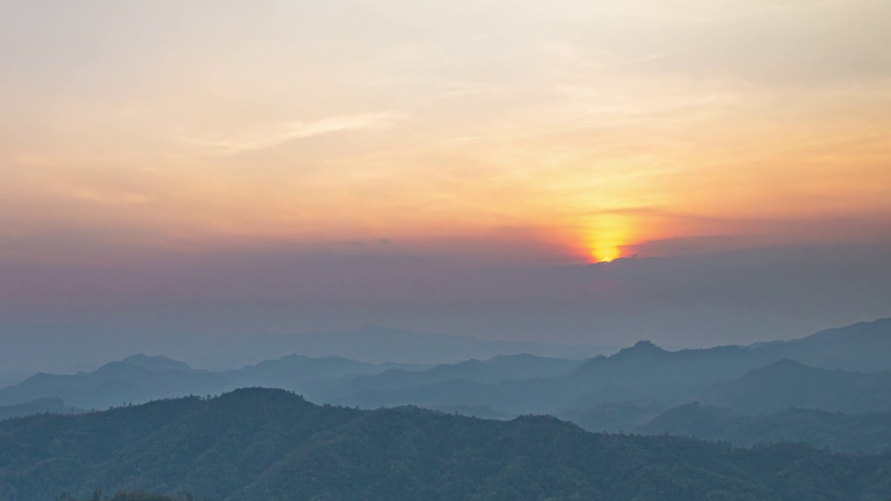 时间的推移，太阳和云朵在夕阳下的山谷中奔跑视频素材