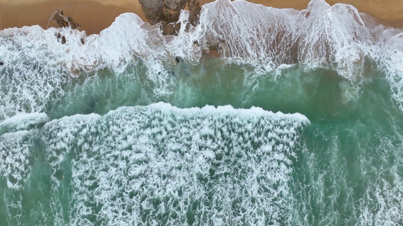 鸟瞰图，海岸线的波浪拍打着岩石视频素材