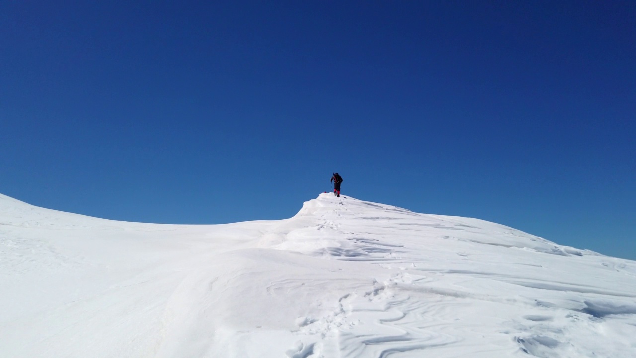 成功的老年登山者是在冬天攀登高海拔雪山峰顶的山脊视频素材