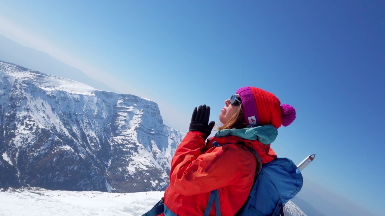 成功的女登山运动员在冬天的时候，在高海拔雪山的顶峰上，正在做祈祷姿势、瑜伽视频素材