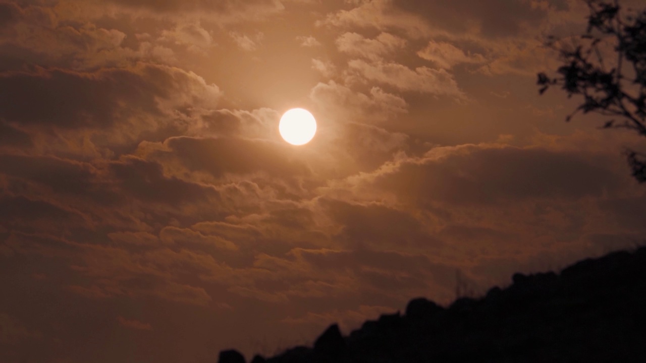 日落时太阳在云层后面的特写镜头。夕阳下的太阳。日落的自然背景视频素材