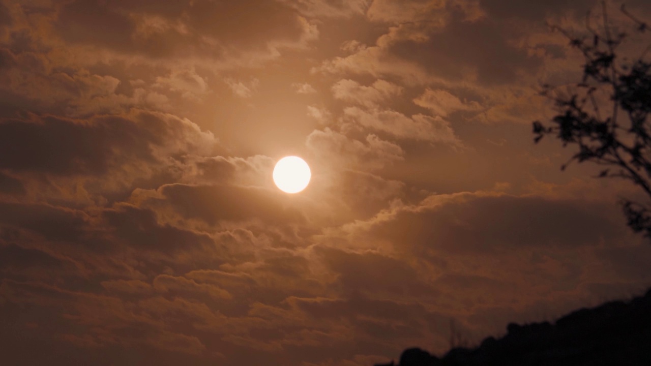 日落时太阳在云层后面的特写镜头。夕阳下的太阳。日落的自然背景视频素材