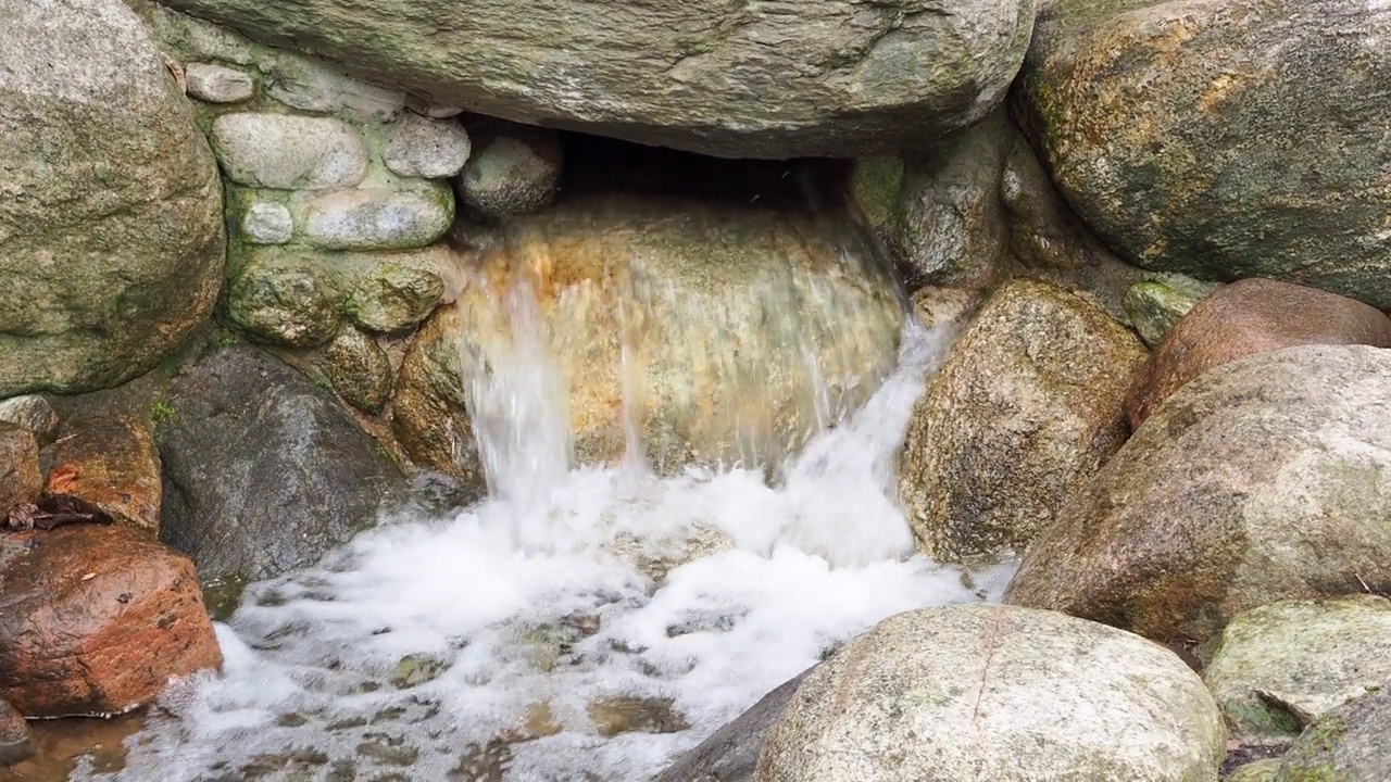 水从岩石上流过。在石头间流淌视频素材