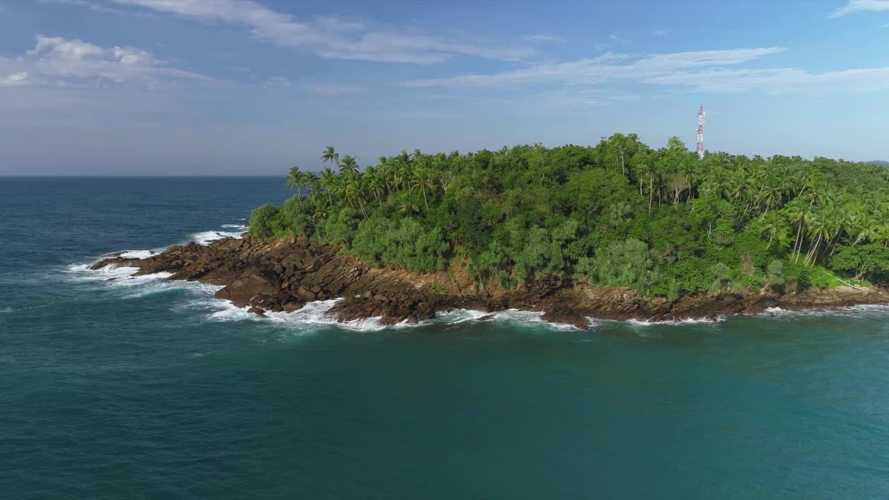 在岩石海岸周围飞行。绕着石头斗篷飞行。波浪拍打着石岬。视频素材