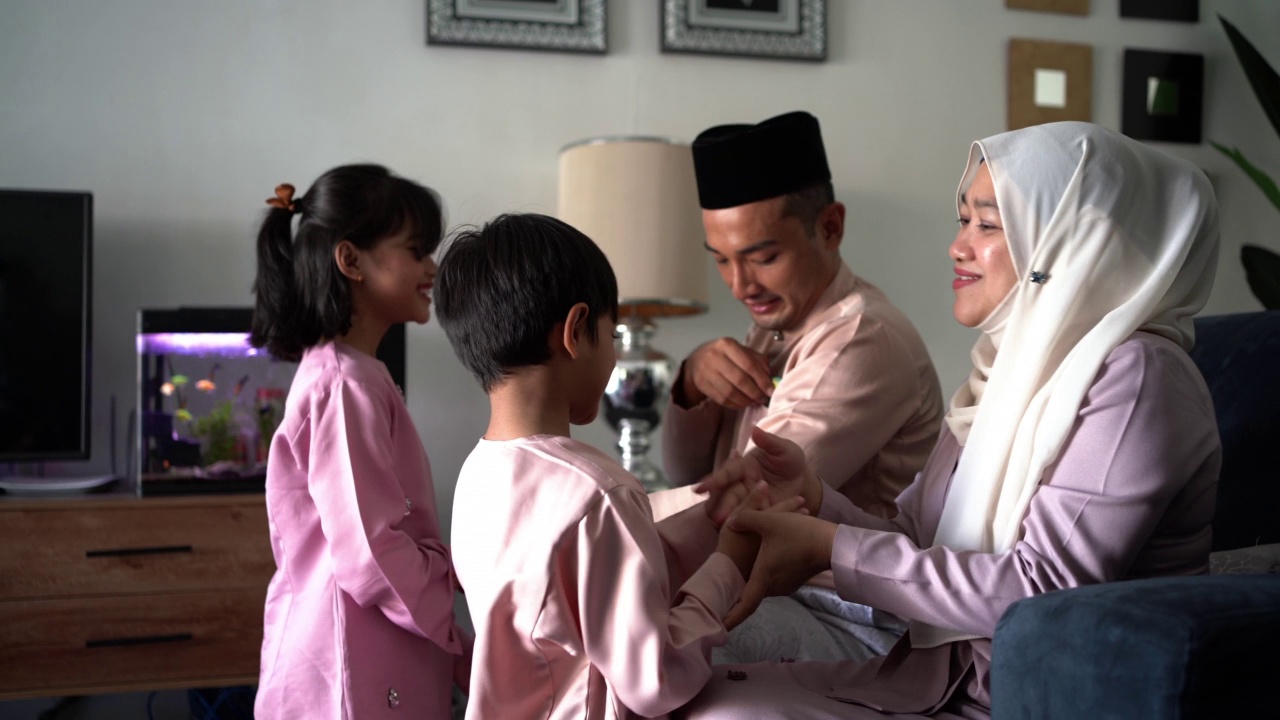 在Hari Raya Aidilfitri庆祝活动中，穿着传统服装的马来族穆斯林孩子向他们的父母请求宽恕视频素材