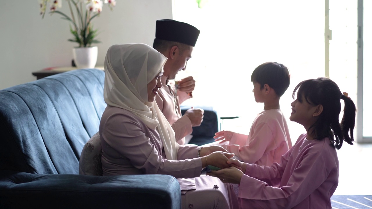 在Hari Raya Aidilfitri庆祝活动中，穿着传统服装的马来族穆斯林孩子向他们的父母请求宽恕视频素材