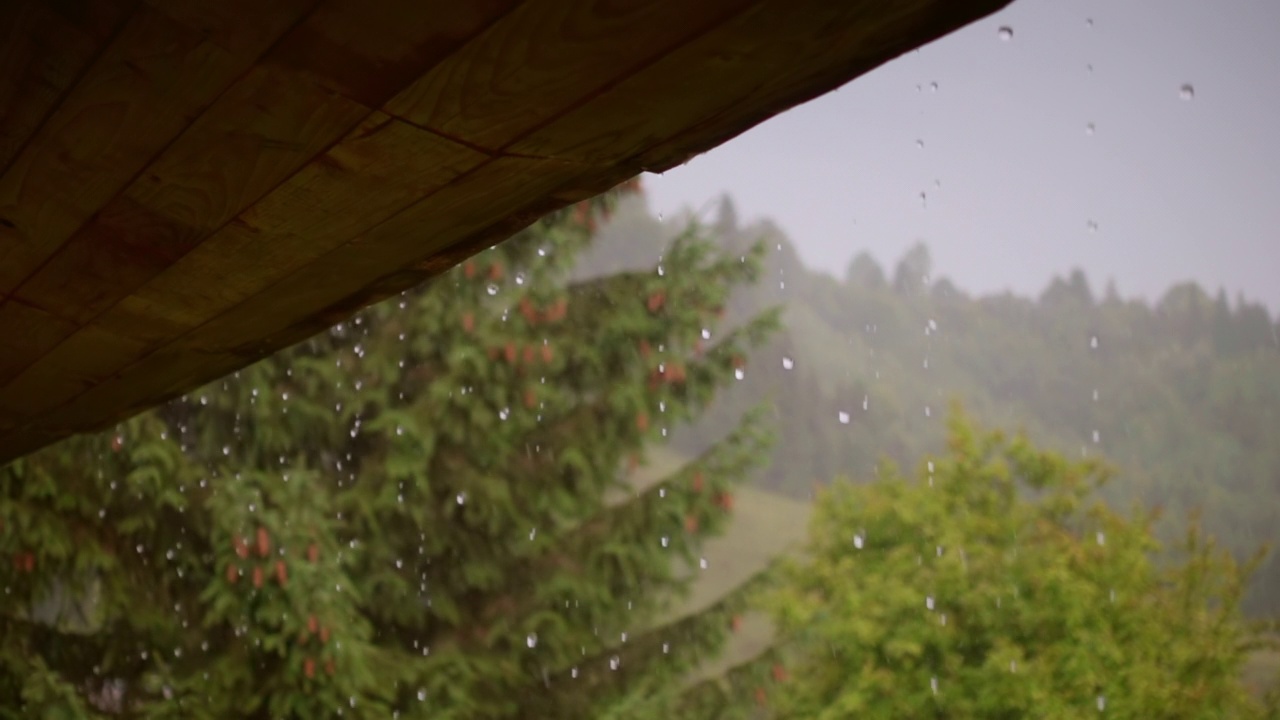 雨水从屋顶流下来。下雨的天气，雨点不断落下。视频素材