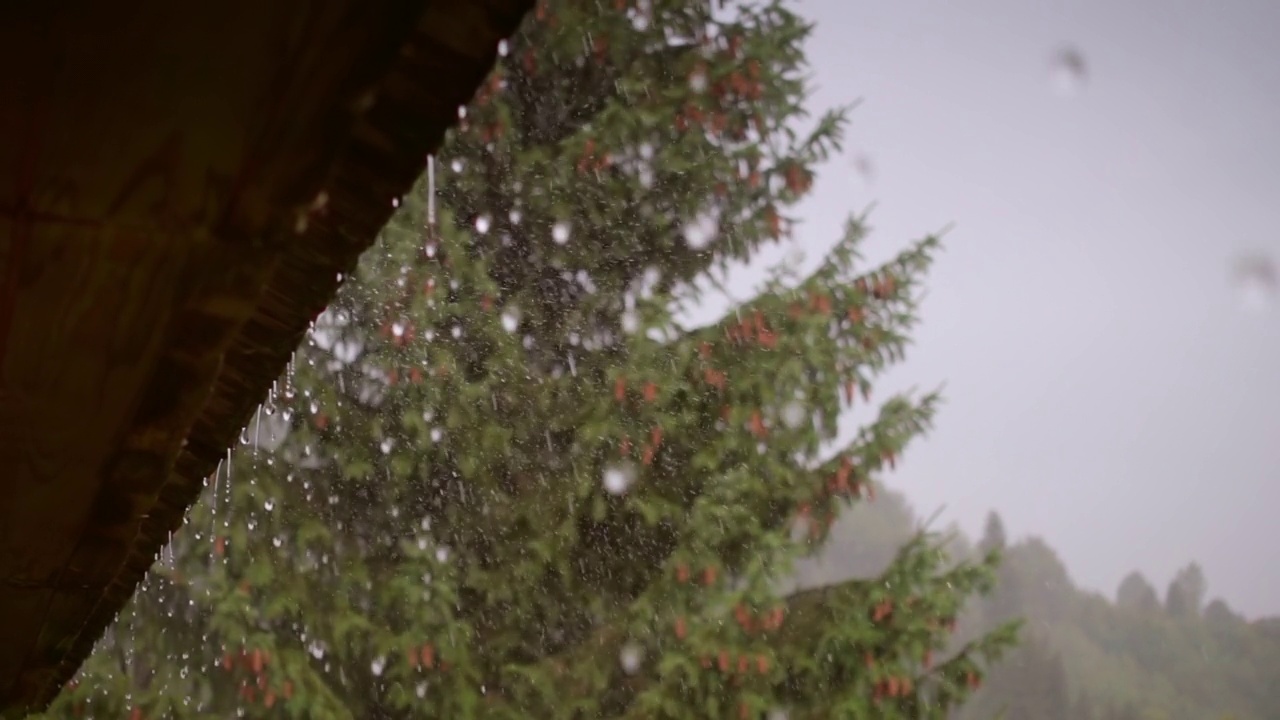 雨水从屋顶流下来。下雨的天气，雨点不断落下。视频素材