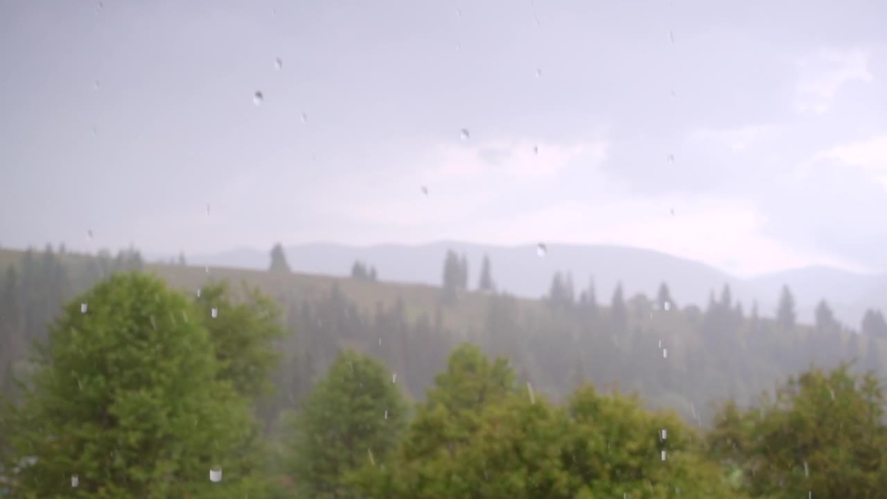 夏天的倾盆大雨漫过绿色的山峦。视频素材