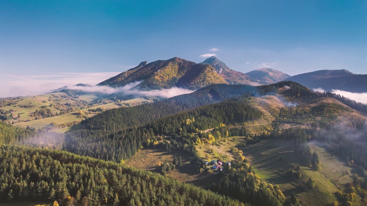 高寒乡村自然的空中超驰，云雾在阳光明媚的秋山中快速移动视频素材