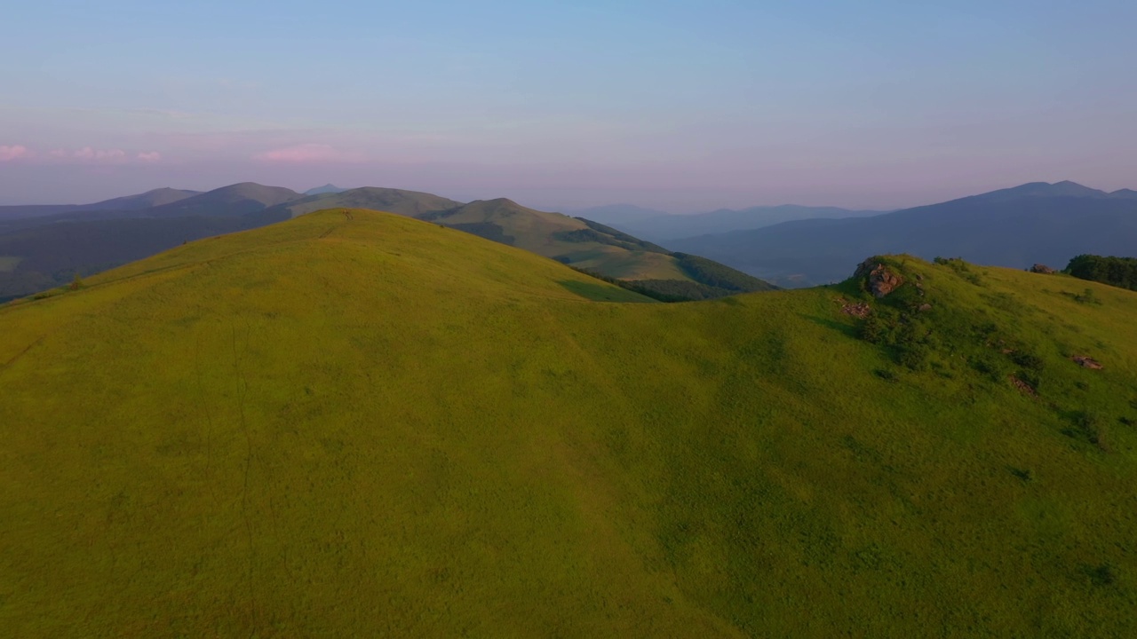 从一架四轴飞行器上拍摄高山高地上的绿色草地。视频素材