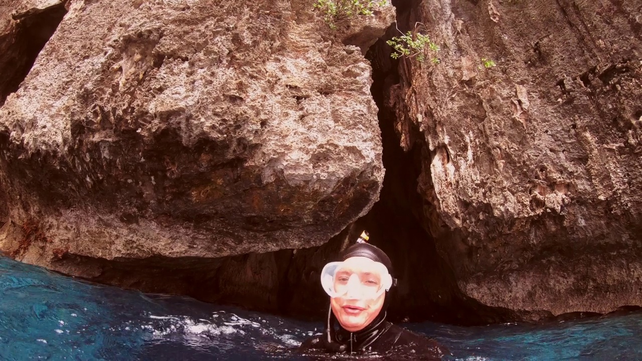 水下拍摄的女潜水员正在探索珊瑚礁壁与生动的海洋生物。视频素材