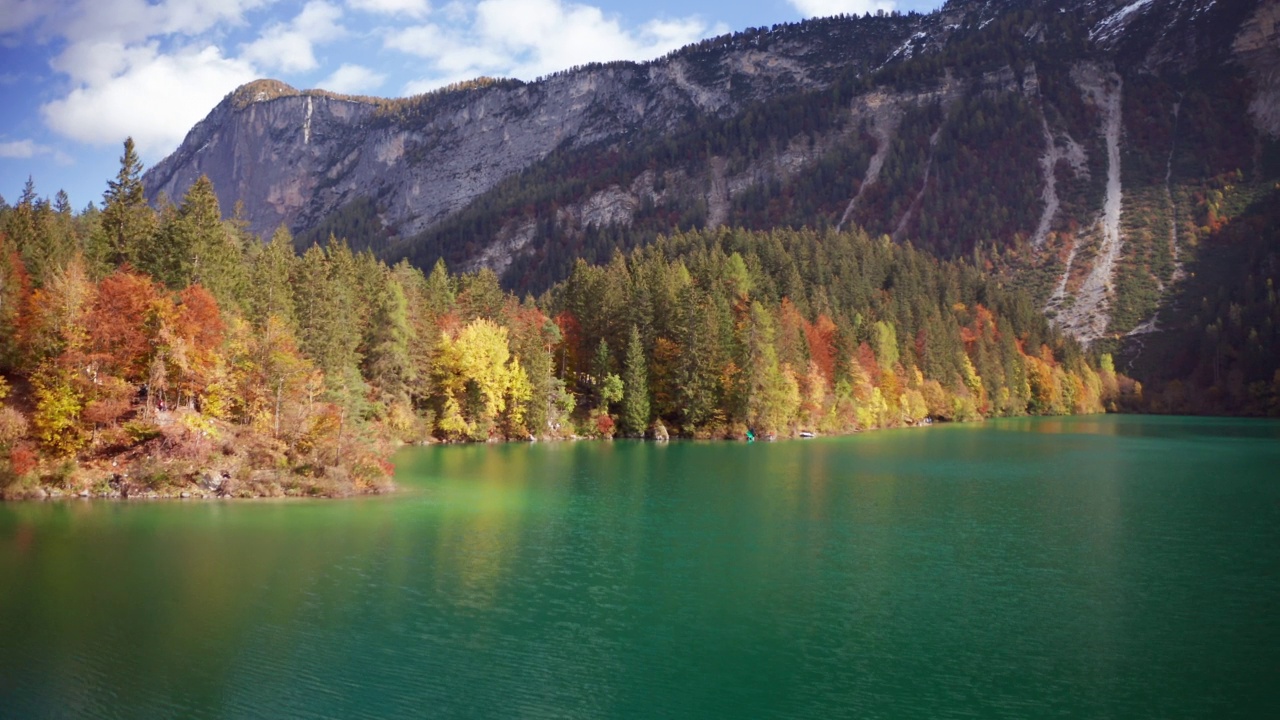 在一个阳光明媚的秋日，航拍的风景全景，山上有树的湖。视频素材