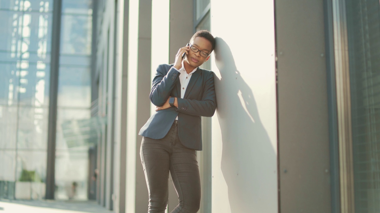 女商人在电话里悲伤的抱怨报告坏消息，非洲裔美国商人在办公室附近绝望的女性，视频素材