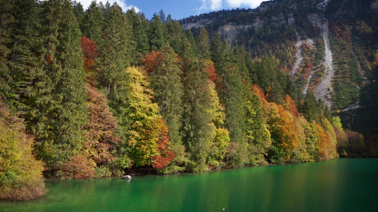 在一个阳光明媚的秋日，航拍的风景全景，山上有树的湖。视频素材