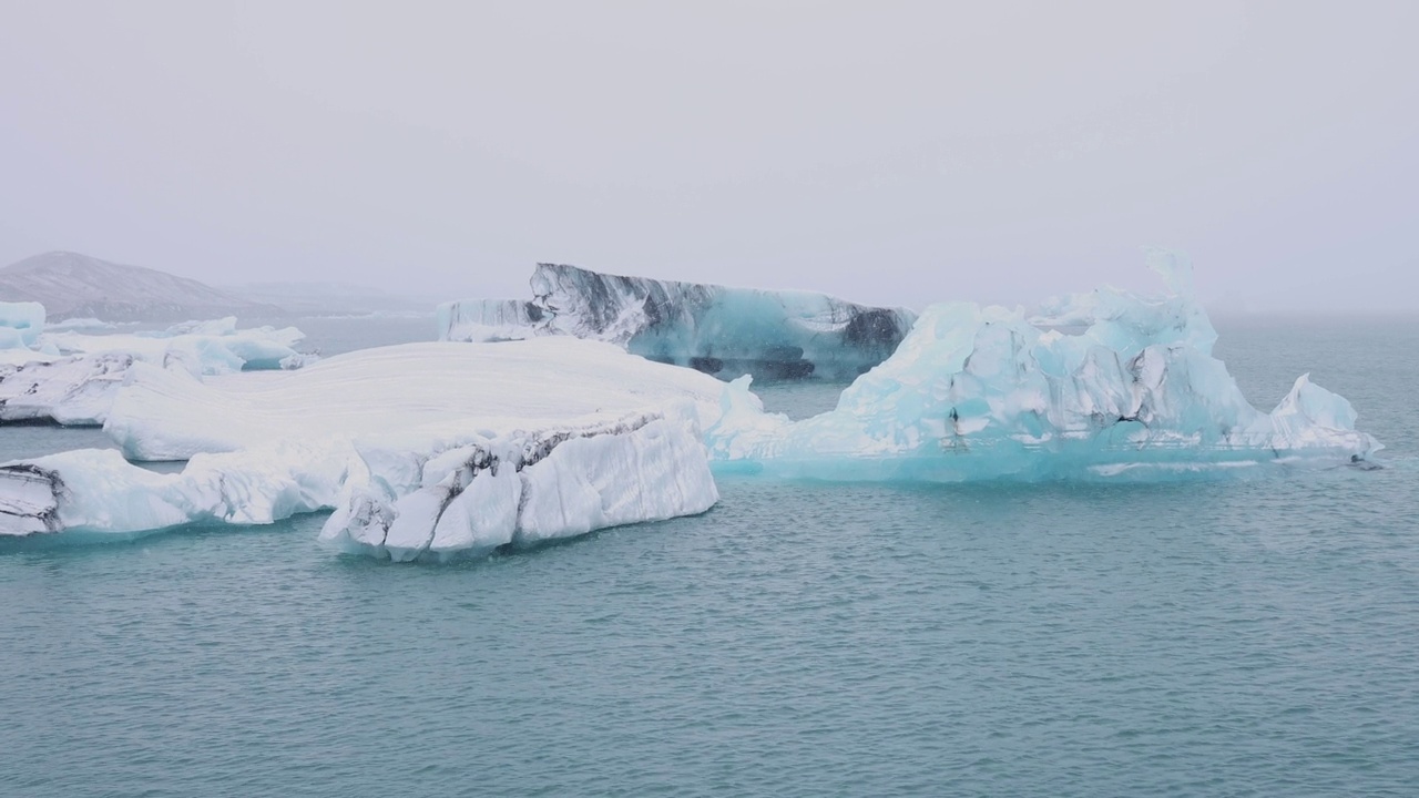 在Jökulsarlon的天然冰川湖泻湖上观看漂流的冰山。ISL视频素材