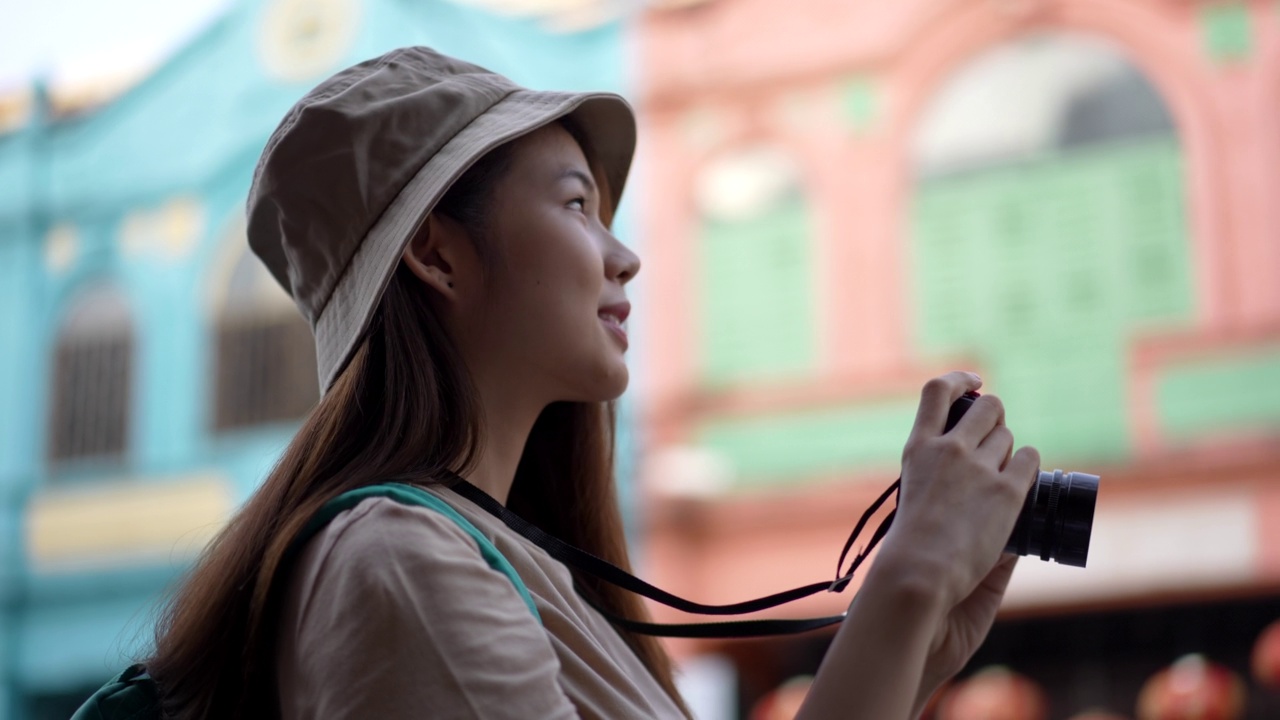 亚洲年轻女性背包客使用相机拍摄地点，同时旅行与快乐的情感表达，独自旅行在生活方式度假夏天。视频素材