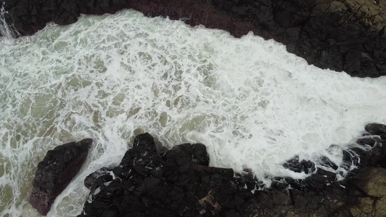 鸟瞰海浪拍打玄武岩火山柱视频下载