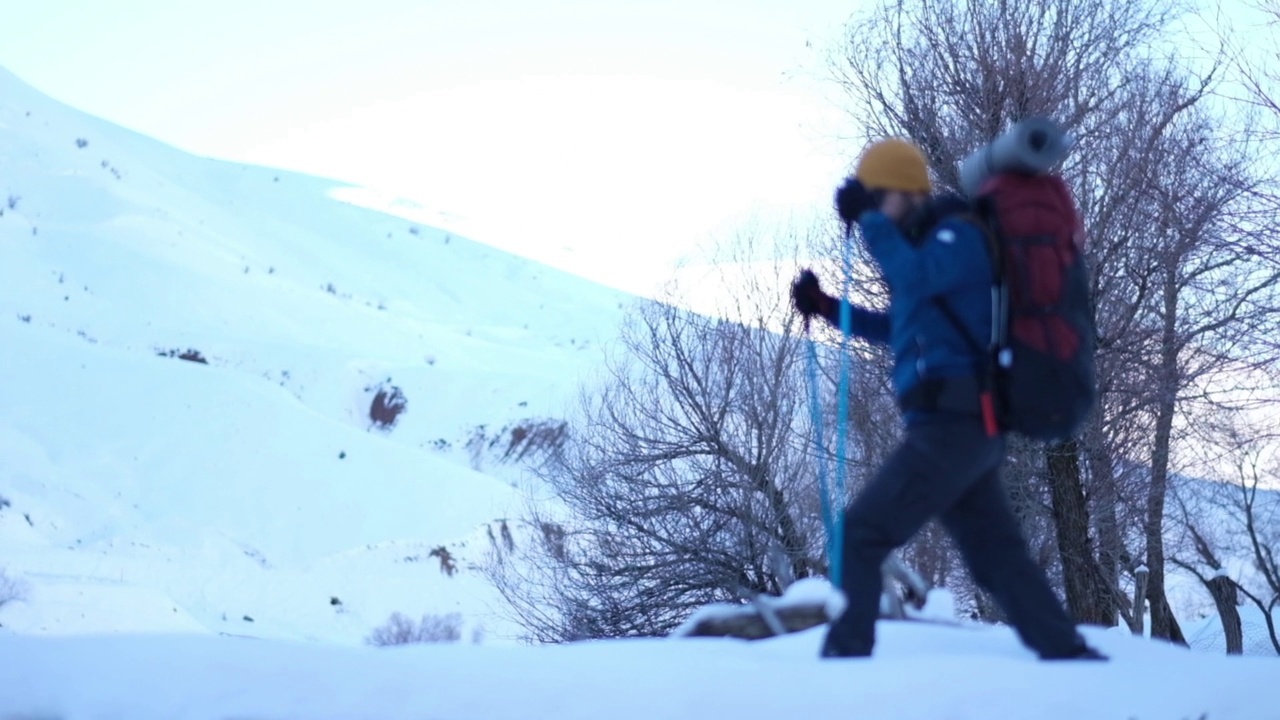 冬天背着背包在山里徒步旅行的人视频素材