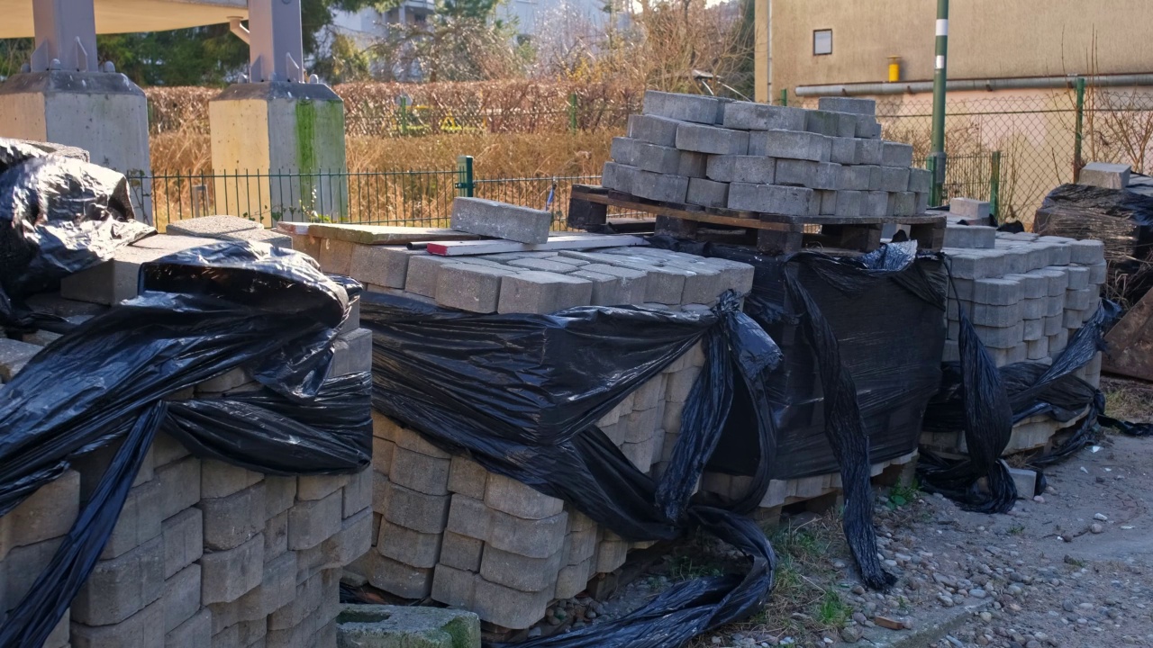 在没有工人在场的情况下，在道路工程建筑工地用黑色塑料薄膜包裹铺路砖视频素材