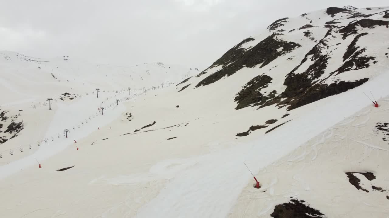 一个关闭的滑雪胜地的全景，山坡受撒哈拉沙漠灰尘的影响，积雪呈棕色视频素材