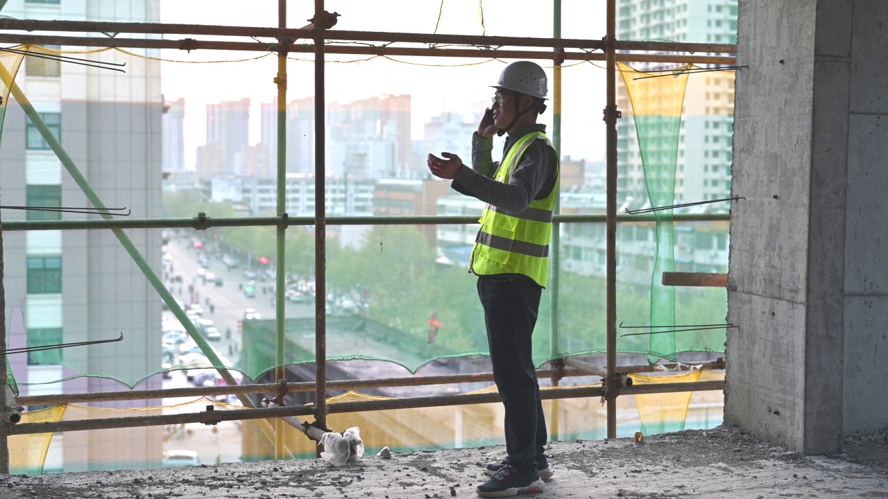 一名男性建筑工程师在建筑工地打电话视频素材