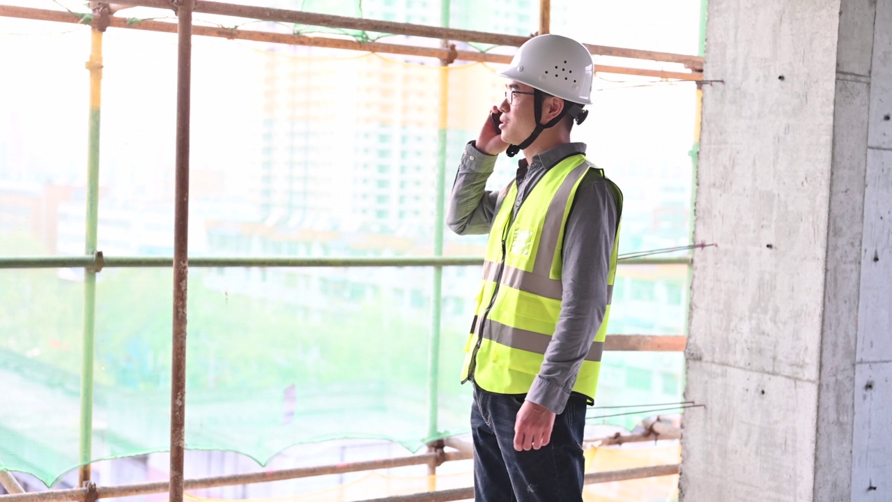 一名男性建筑工人在建筑工地打电话视频素材