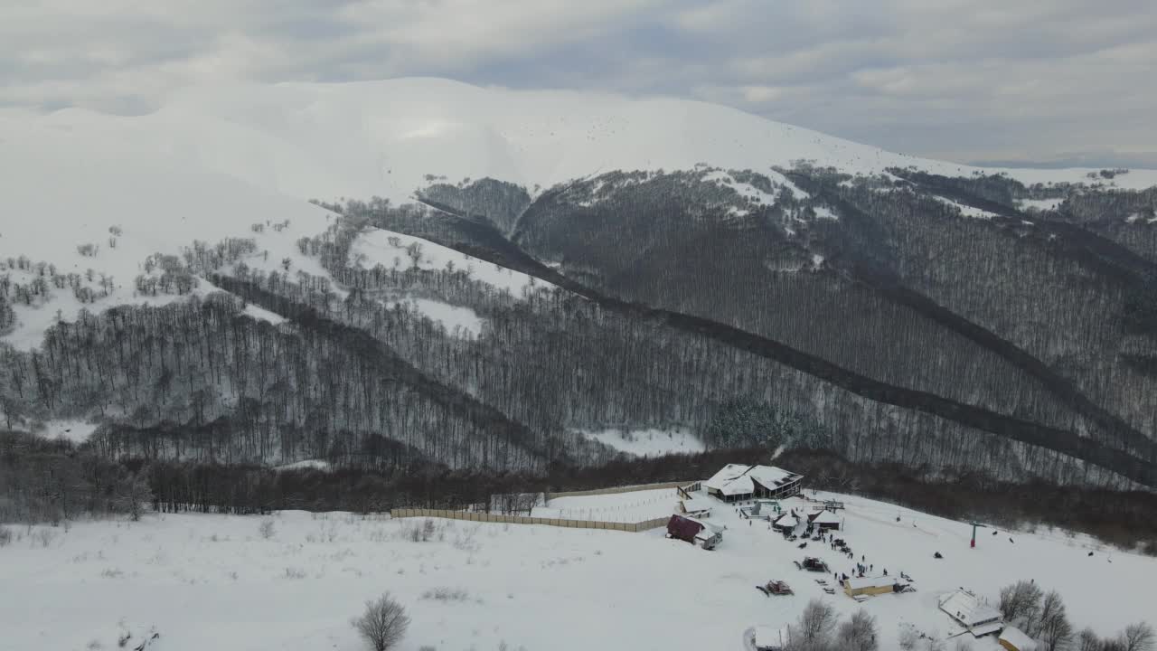 令人惊叹的空中飞行在雾蒙蒙的山脉，草地和冰雪覆盖的山峰在冬天的时间。乌克兰喀尔巴阡山脉，金巴山，4k鸟瞰图。视频素材